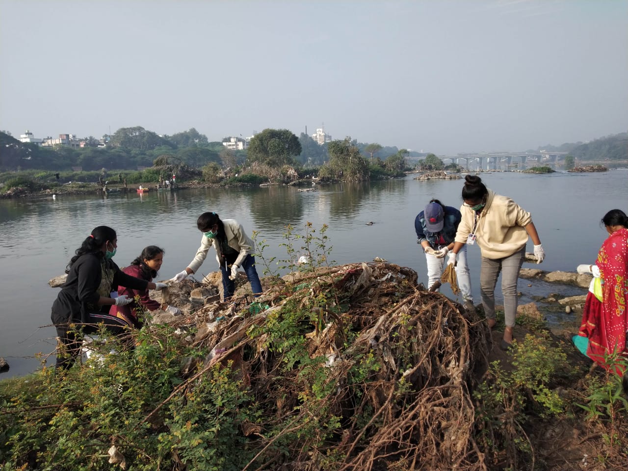 Volunteers cleaning the bushes off the garbage 1